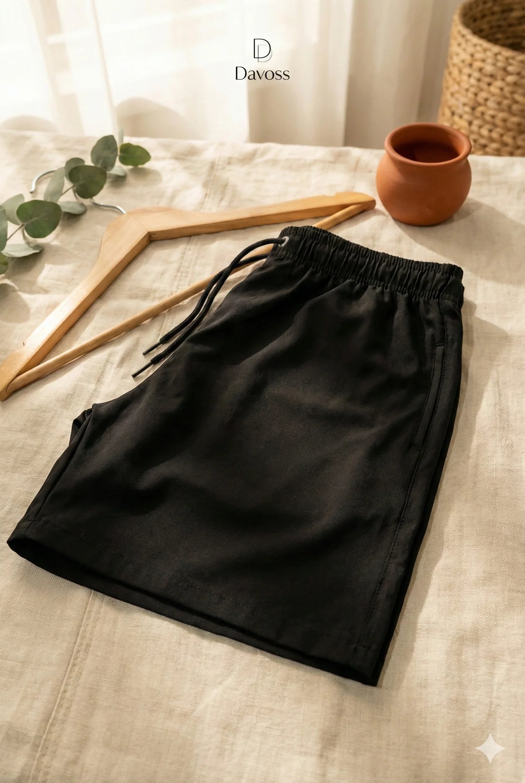 Bermuda masculina tactel com elastano na cor bege disposta horizontalmente sobre uma mesa branca, mostrando o corte reto, o cós com cordão e o design casual da peça.